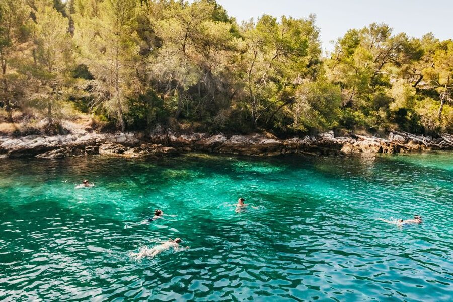 A boat anchored in a pine-lined cove off Šolta, an hour from Split harbour